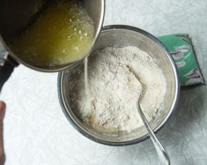 pouring butter into flour mixture in bowl