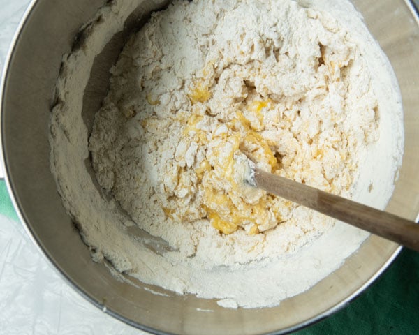 stirring flour into a dough in a bowl