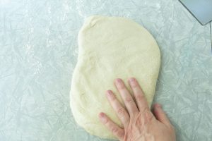 patting bread dough into rectangle