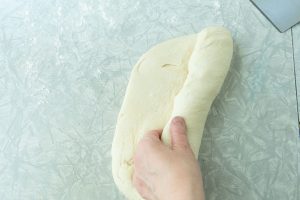 rolling log of bread dough for bread