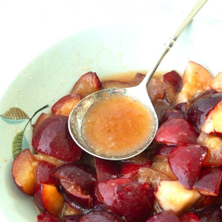plums and sugar in bowl with spoon