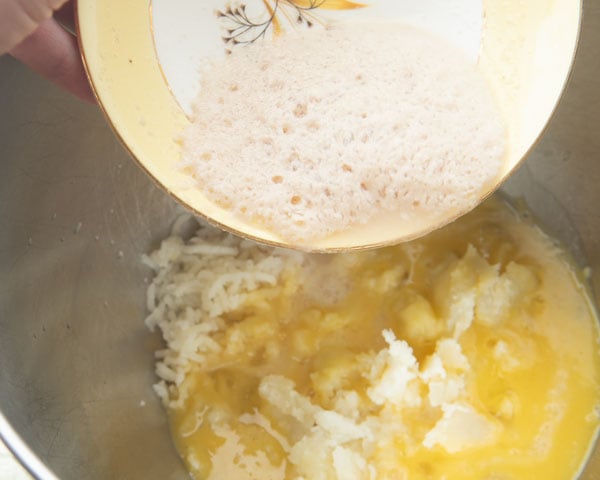 pouring yeast water into a bowl with mashed potato and eggs