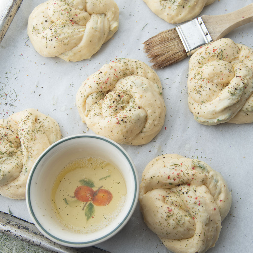 brushing potato garlic knots with egg white