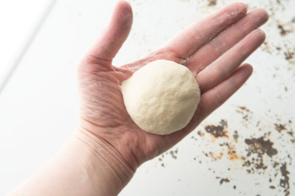 pita bread dough ball in hand