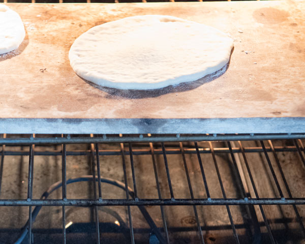 pita dough on hot pizza stone