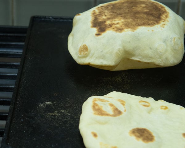 pita breads on cast iron griddle finishing cooking