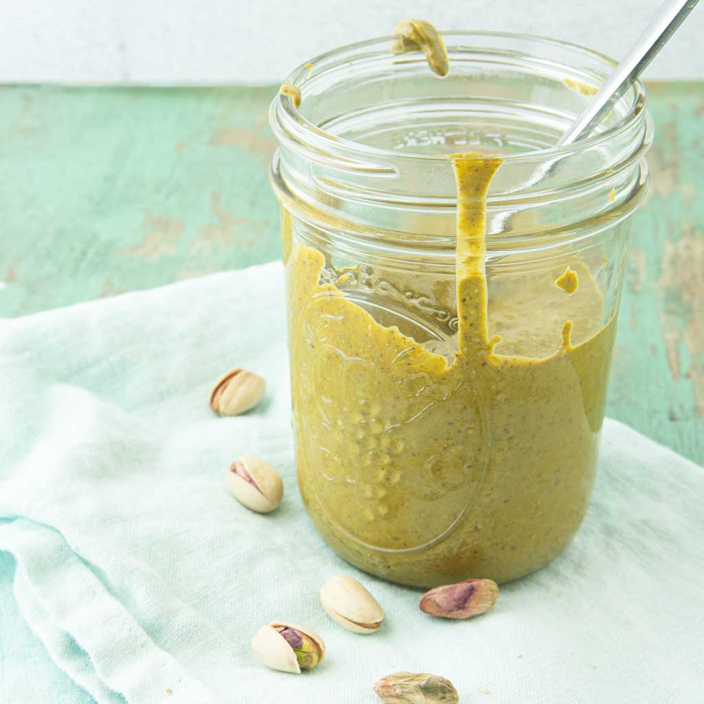pistachio butter in jar with whole pistachios