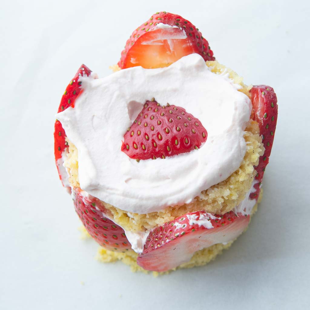top of strawberry mini cake covered with cream and strawberry slice