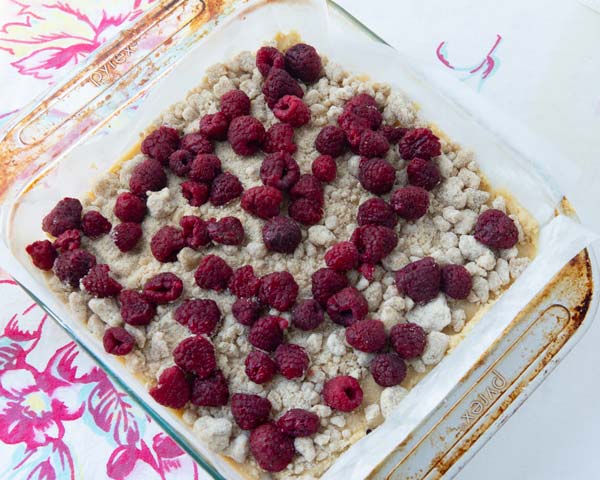 raspberries on top of cake batter in pan