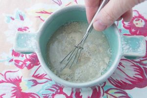 dissolving yeast into water with whisk