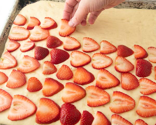 tiling strawberry slices on yeast dough