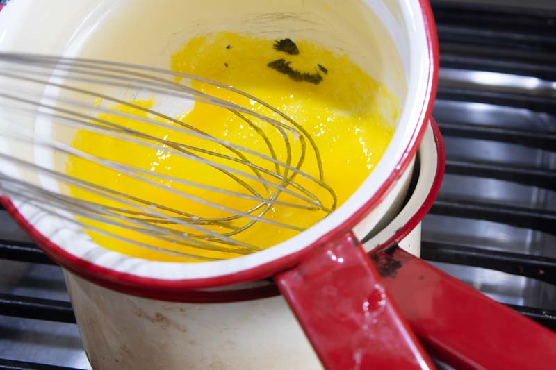 whisking egg yolks over simmering water