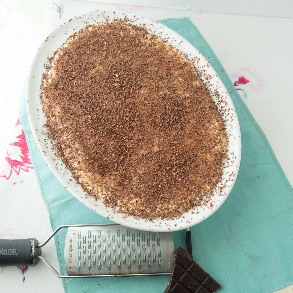 tiramisu in dish with chocolate and grater