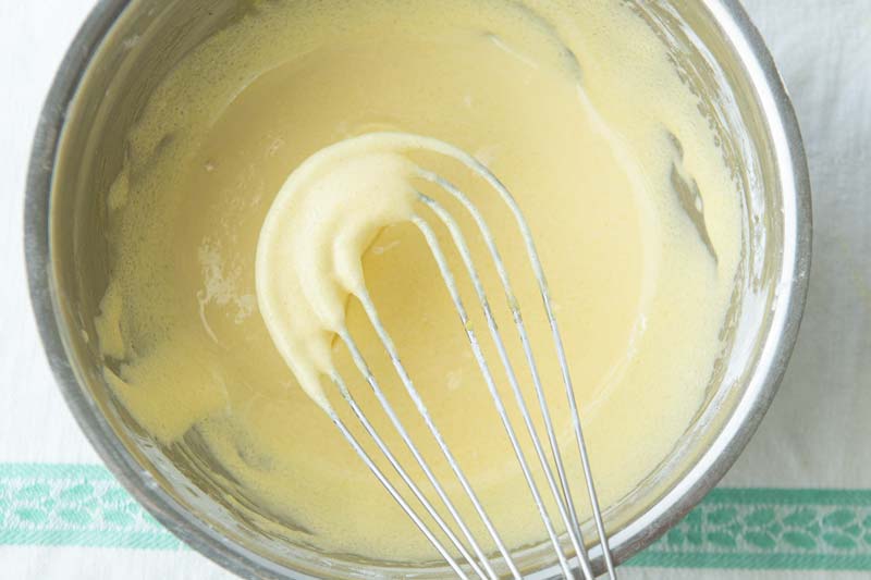 whisking eggs into sugar and starch for pastry cream