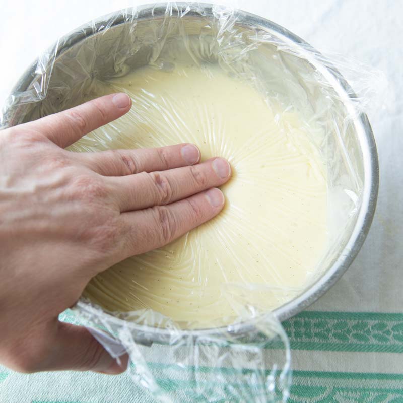 pressing plastic wrap on surface of pastry cream