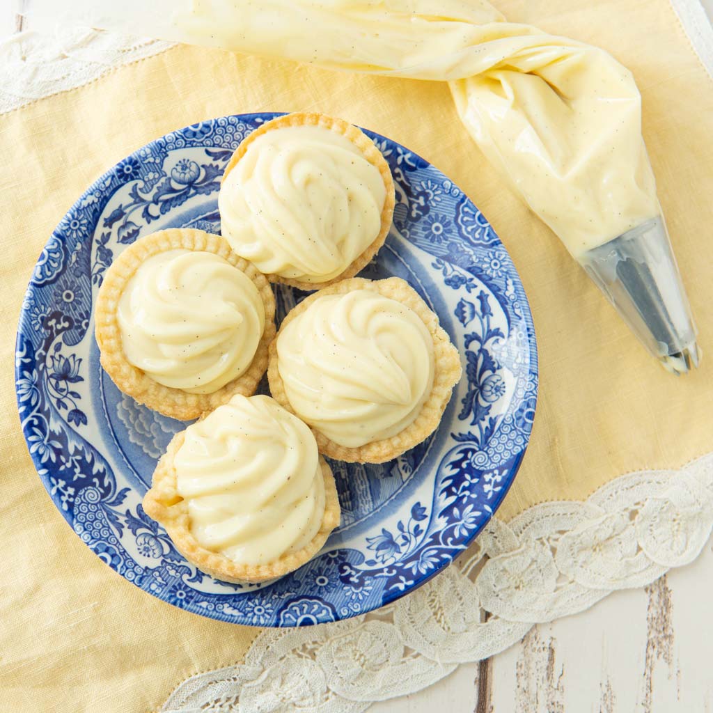 vanilla pastry cream in pastry shells with piping bag