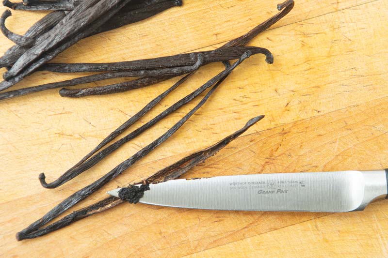 scraping vanilla bean seeds from pod with knife