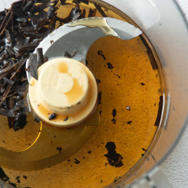 chopped vanilla beans in food processor bowl with honey