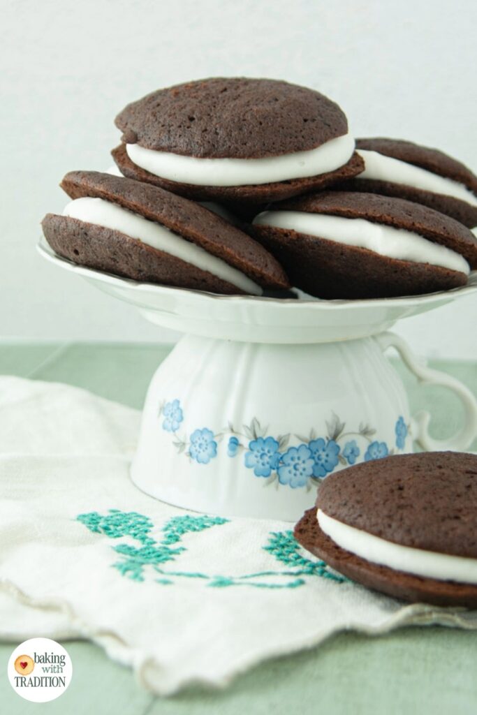 soft chocolate sandwich cookies filled with whipped cream on plate and napkin