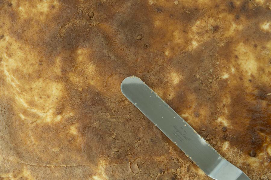 spreading cinnamon sugar and butter on dough with spatula