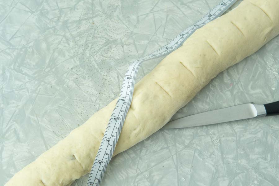 marking cut lines for cinnamon rolls with knife and measuring tape