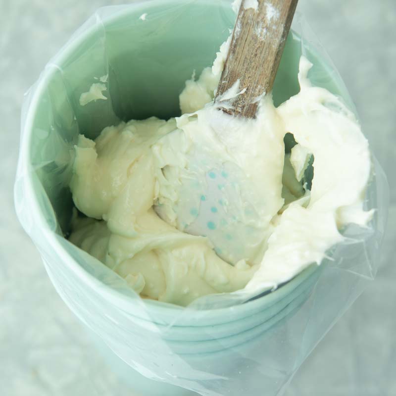filling pastry bag with cream cheese icing with spatula