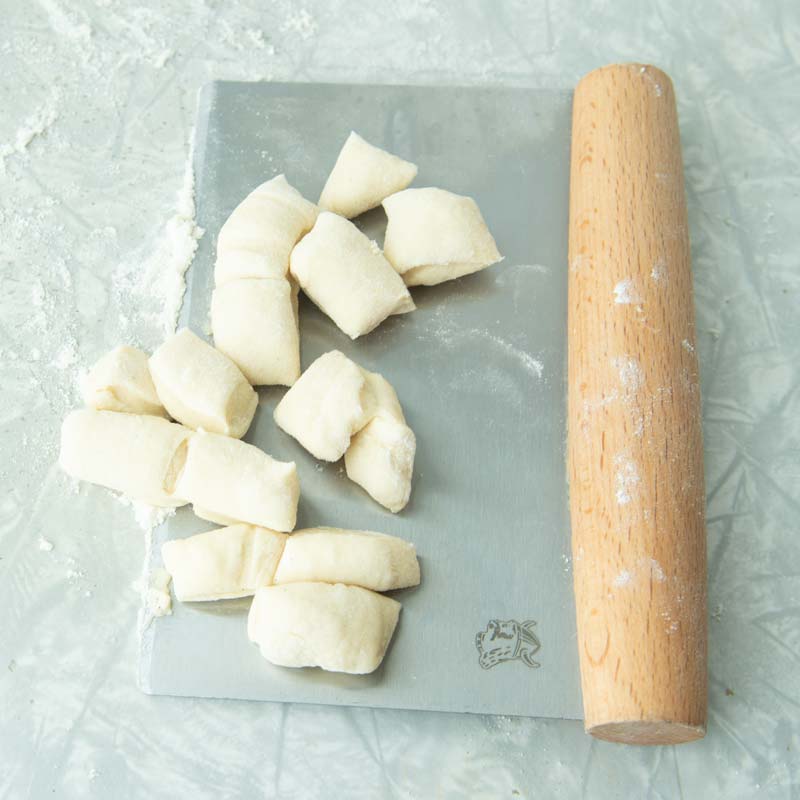 cutting dough into tiny pieces with bench scraper