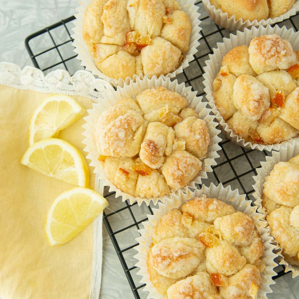 baked lemon monkey bread muffins on wire rack with lemons and napkin