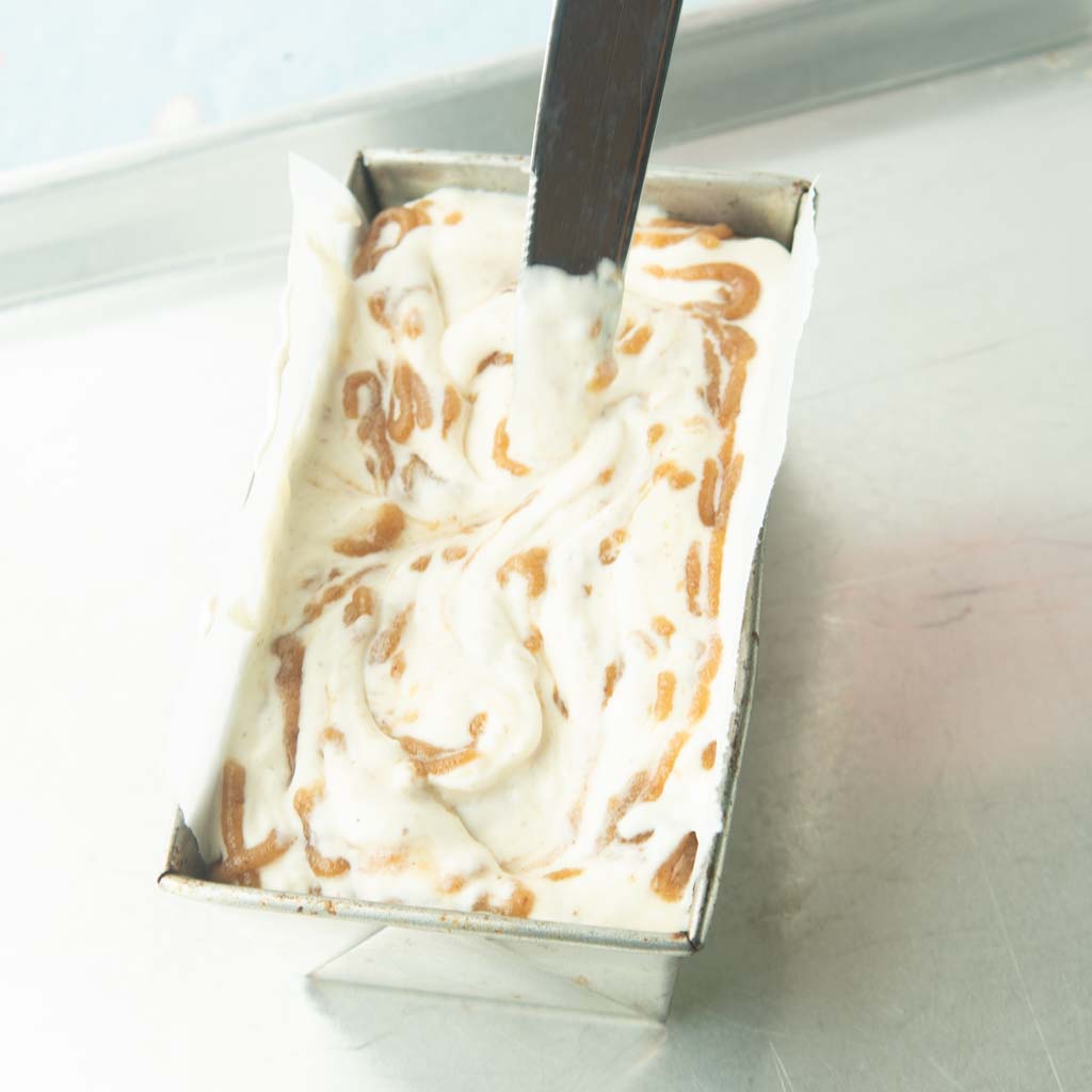 swirling caramel into ice cream with knife