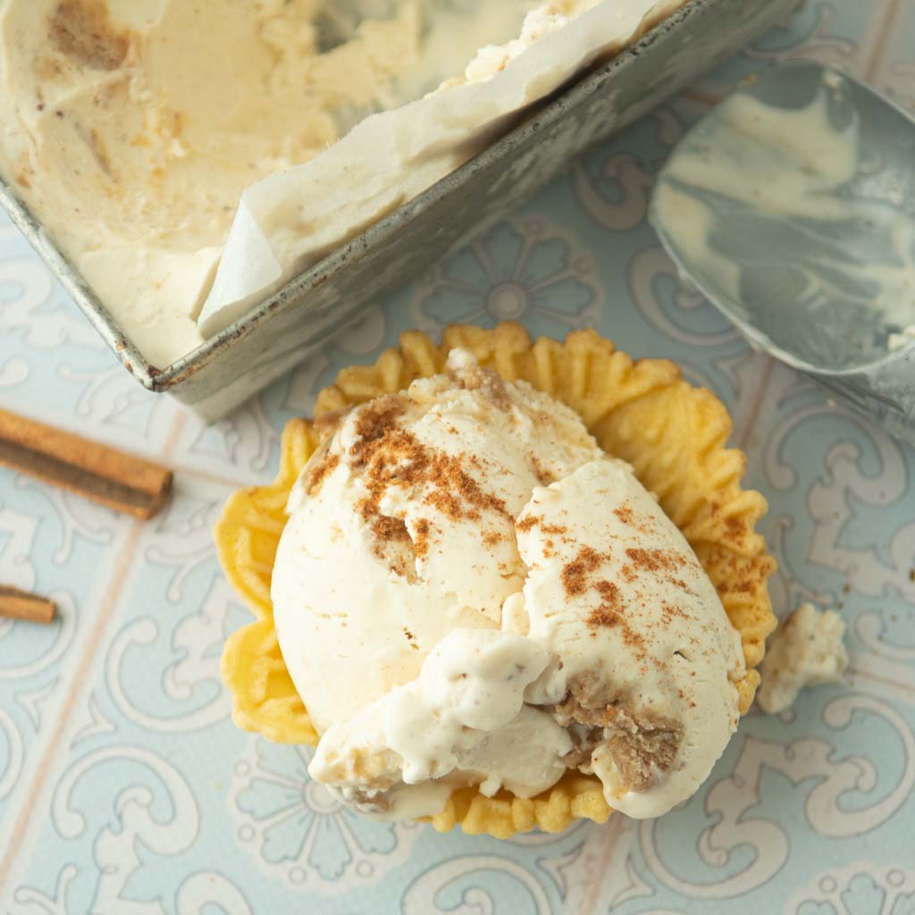 no-churn cinnamon ice cream in pizelle waffle cups, ice cream scoop, and loaf pan