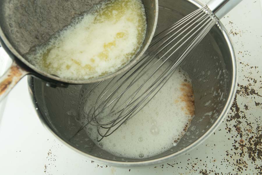 pouring vanilla and butter into egg whites