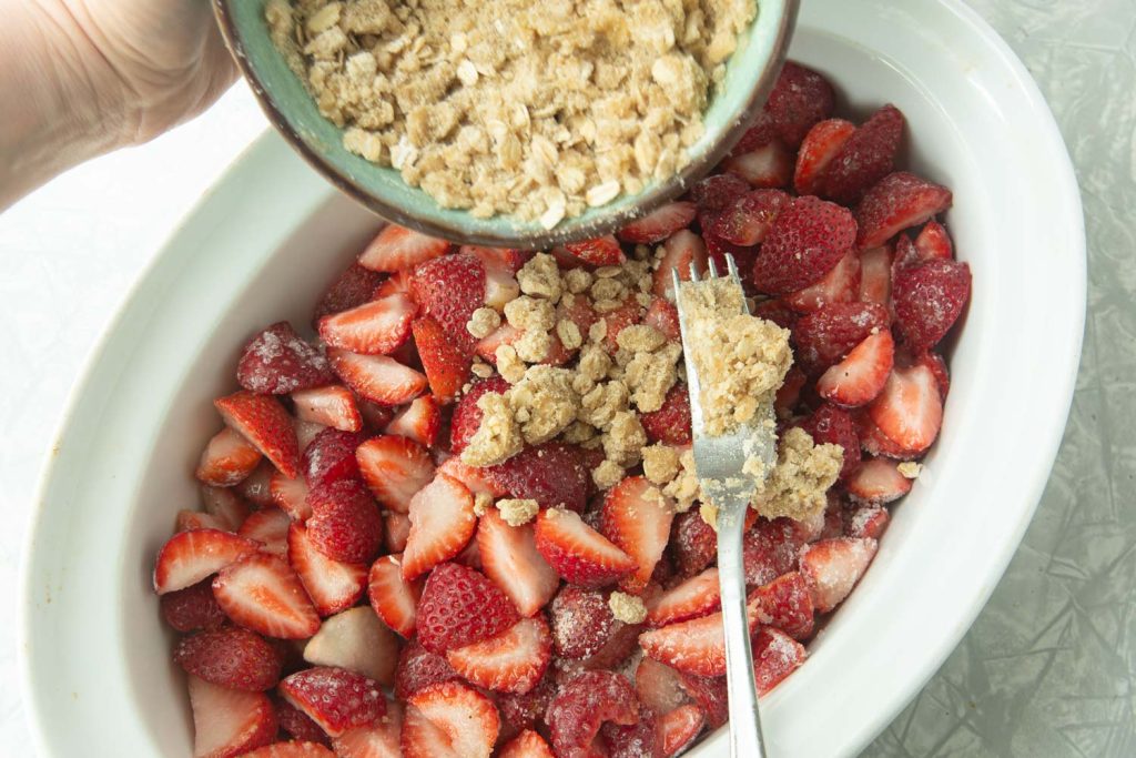spreading streusel over strawberries