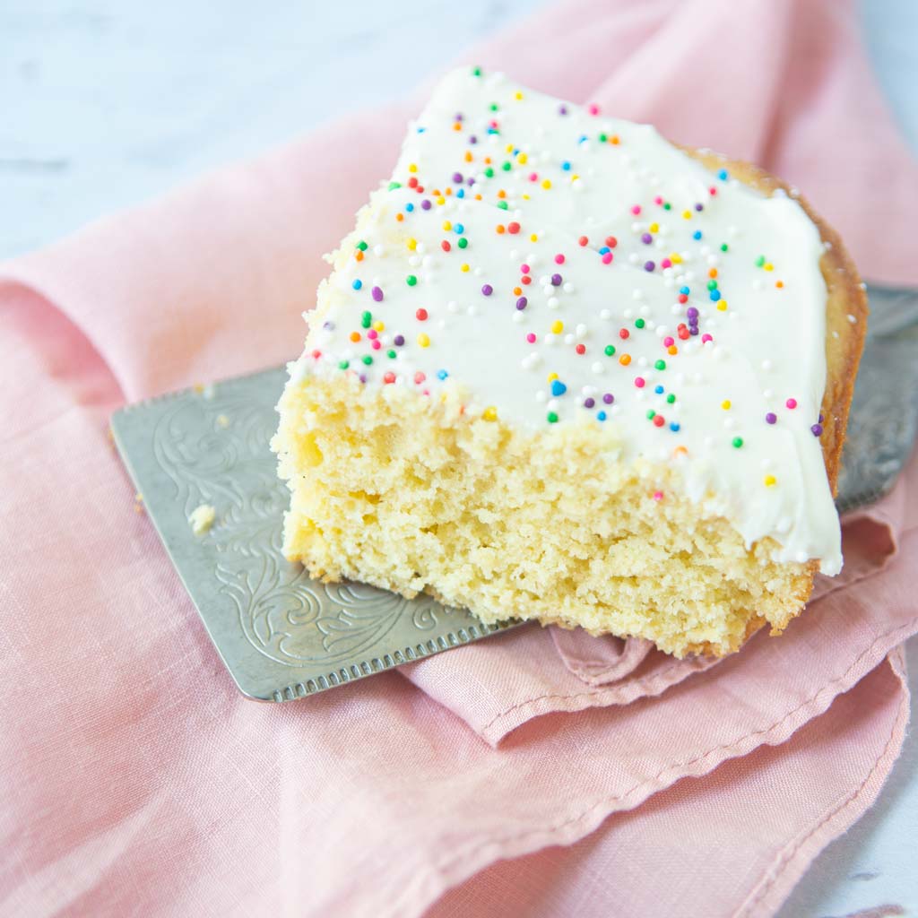 piece of vanilla sheet cake on cake server