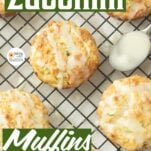 lemon zucchini muffins on wire rack with lemon drizzle, spoon, text overlay