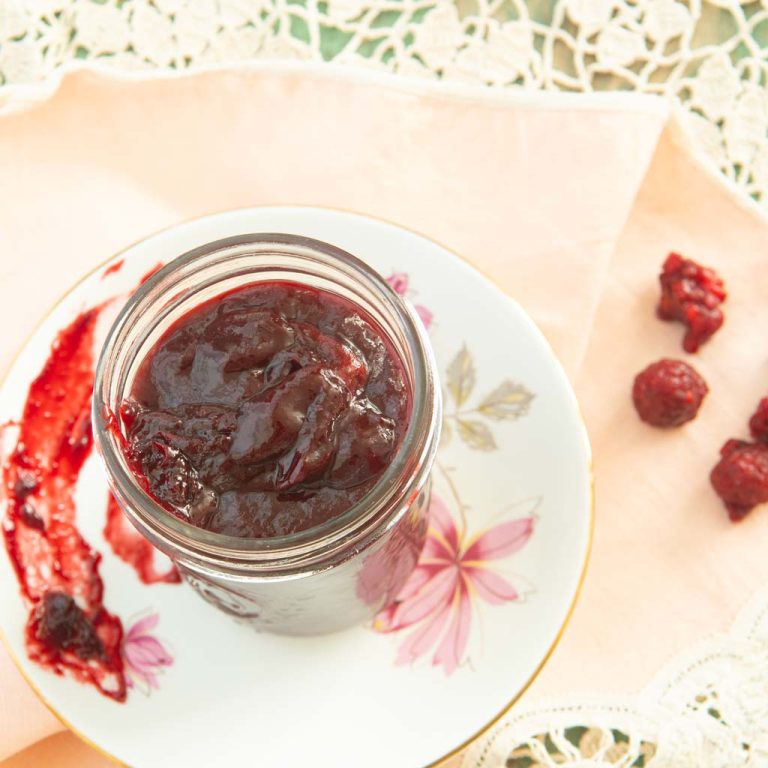 homemade raspberry jam on plate with raspberries