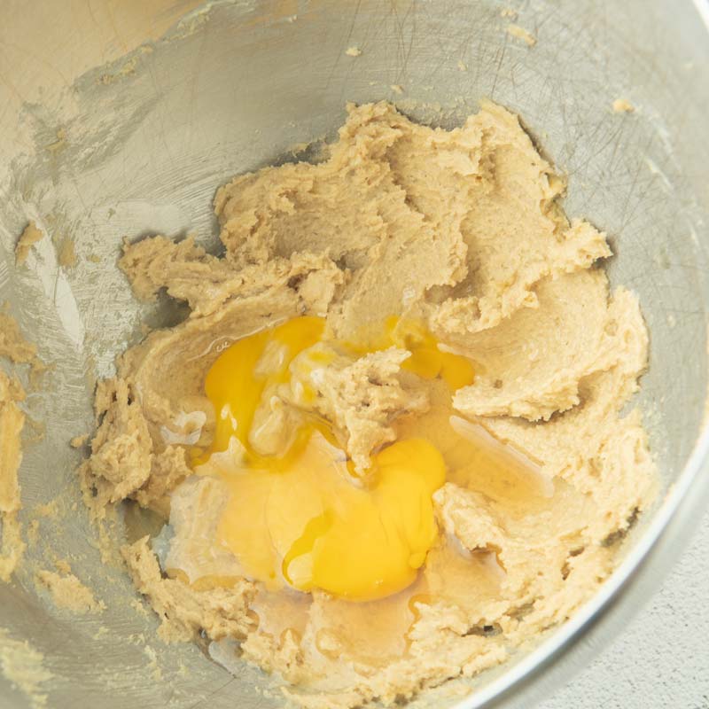 adding egg and whiskey to butter and brown sugar
