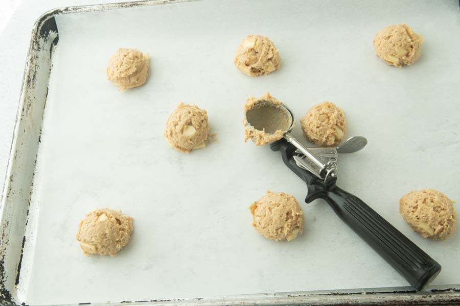scooping caramel apple cookie dough onto sheet trays