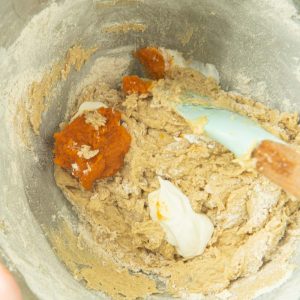 adding sour cream and pumpkin to pumpkin cookie dough