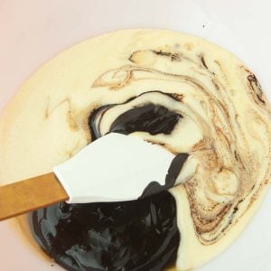 mixing eggs and sugar into melted chocolate and butter