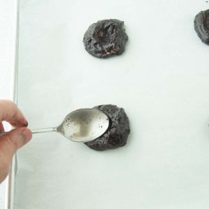 making well in center of brownie cookies with spoon