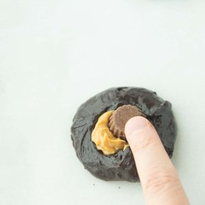 placing peanut butter cup on brownie cookie