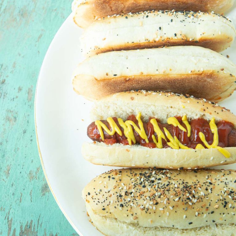homemade hot dog buns on plate with one hot dog with ketchup and mustard