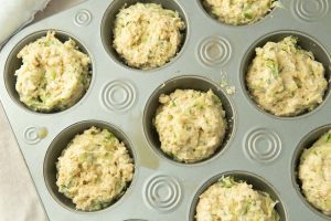 zucchini muffin batter in muffin tin before baking