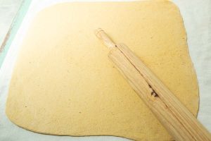 rolling out pumpkin cinnamon roll dough