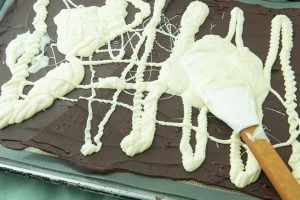 spreading white chocolate on dark chocolate with spatula