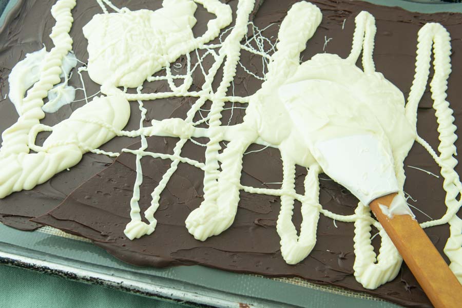 spreading white chocolate on dark chocolate with spatula