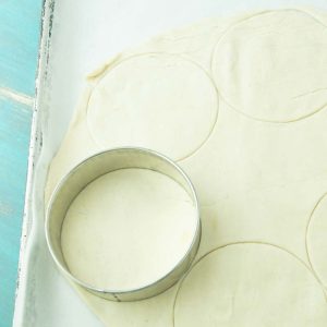 cutting rounds of pie dough with circle cutter