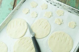 cutting pie dough rounds partially with knife