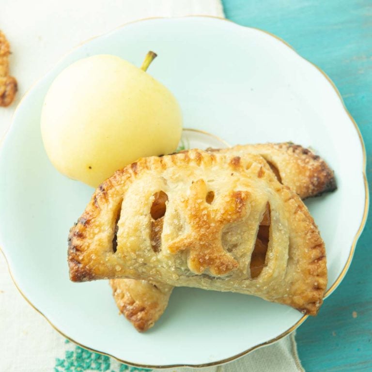 closeup of apple hand pies on plate with apple