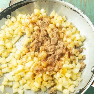 adding sugar and cinnamon to apples in skillet